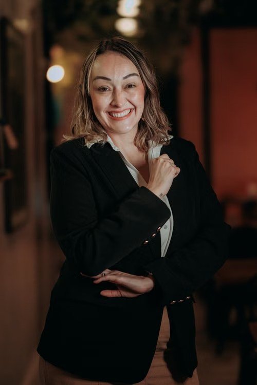 Portrait of a smiling client in a dimly lit venue.