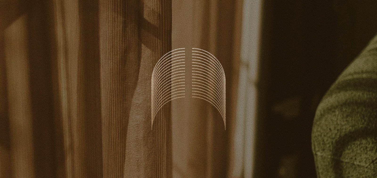 Abstract arched line motif overlaid on a warm, textured curtain backdrop.